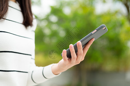 女性使用移动电话的情况女孩身体细胞短信公园游戏电话女士绿色阅读图片