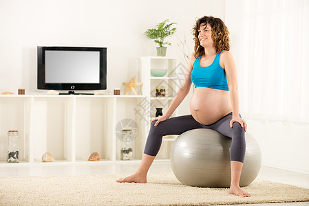 怀孕妇女母性微笑女性女士护理健身水平休息幸福腹部背景图片