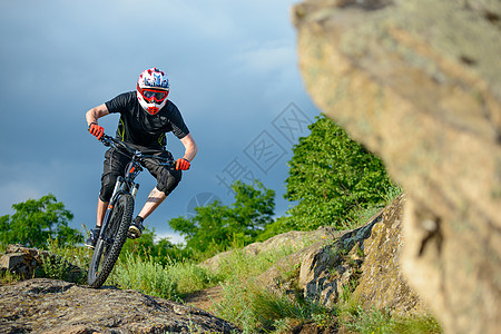 在美丽的春山轨上骑自行车的专业赛车员 极品体育界的极端运动头盔爬坡男性成人岩石男人车轮踪迹天空骑士图片