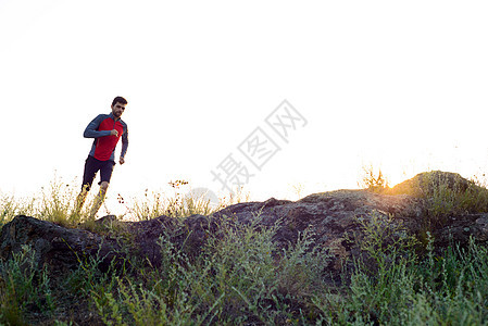 年轻运动员跑在日落日落的洛基山轨上 活跃生活方式公园天空岩石健康卫生慢跑者运动日落跑步活动图片