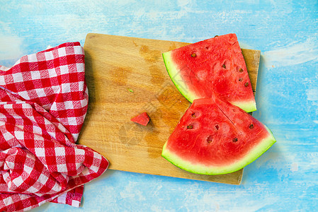 生锈蓝色木制桌边的西瓜水果切片种子健康饮食桌布乡村日光桌子季节食物高架饮食图片