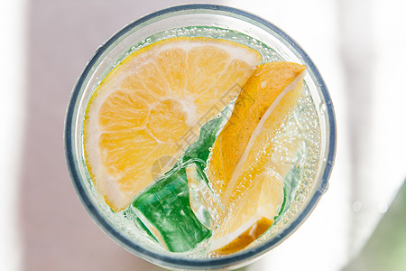 一杯含柠檬和冰的莫吉托咖啡手指玻璃桌子叶子烹饪材料饮料派对液体柜台图片