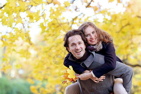 秋天公园的拥抱情侣女士公园乐趣快乐男人夫妻骑术恋人男朋友女朋友图片