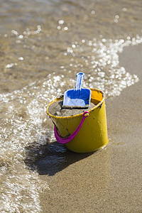 在海滩海岸上的玩具斯派德和巴克特波浪涟漪粉色支撑蓝色黄色图片