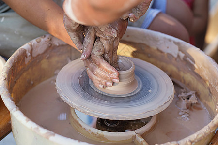 陶匠的手 在圆圈上制造一个土罐子工作孩子陶瓷老师手工孩子们血管硕士工匠压力图片