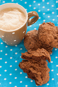 蓝餐巾纸上加一杯咖啡的巧克力美食饼干烘烤温度可可甜点杯子牛奶酥皮咖啡店桌子食物图片