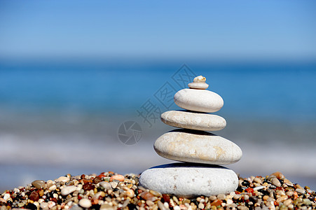 海滩上一块大石头上的一堆鹅卵石图片