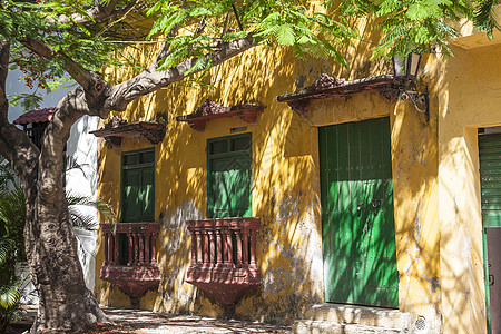 在卡塔赫纳德印第亚斯的一栋房子阴影黄色阳台古董遗产历史性绿色历史殖民建筑学图片