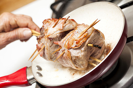 棕褐色的培根缠在牛肉领皮奖章上烹饪熏肉嫩肉肉片猪肉灼烧牙签棕色背景图片
