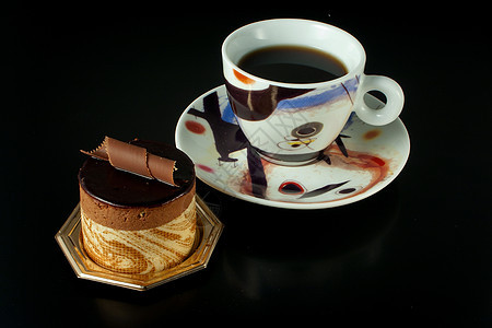 黑底黑色巧克力糕点和咖啡杯面图片