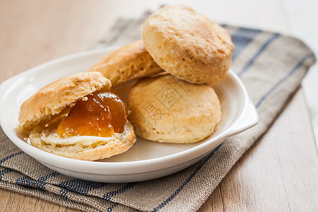 黄油和果酱的松饼 在餐巾纸和果酱银行毛巾文化勺子奶油面包粮食小吃桌子明胶甜点图片