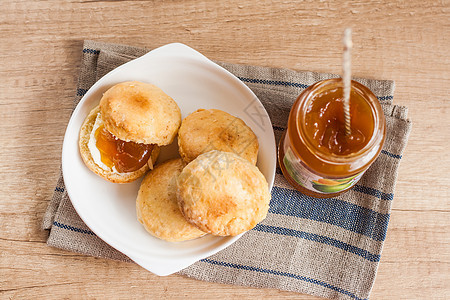 黄油和果酱的松饼 在餐巾纸和果酱银行盘子文化毛巾烘烤小吃美食面团橙子木头杯子图片