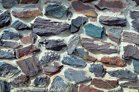 以彩色夸脱墙形式出现的纹理栅栏建造岩石石英岩裂缝矿物花园建筑学花岗岩矿石图片