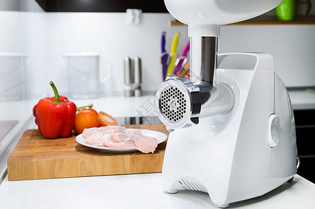 现代厨房的肉研磨机 背景蔬菜图片
