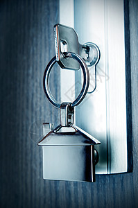 带有银色铬叠合剂的房子密钥金属安全吊坠房门房地产锁孔合金钥匙背景图片