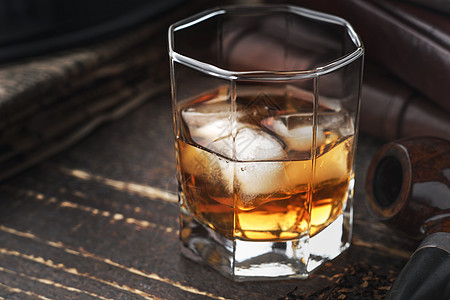 木制桌上有冰和管子的威士忌白色冰块棕色管道绅士笔记本桌子酒精水平烟草图片