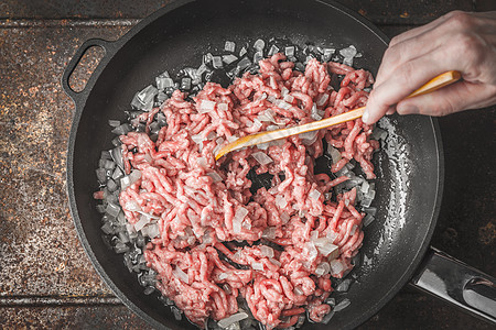 生肉夹在锅里切洋葱 手拿木勺子棕色黑色食物烹饪营养美食白色蔬菜水平红色图片