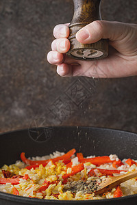 将黑胡椒加在锅里 加上大米和铃辣椒垂直食物蔬菜美食平底锅健康海鲜饭玻璃金属摇床桌子图片