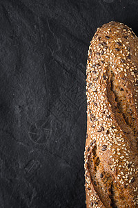 黑石桌垂直背面有谷物和种子的面包图片