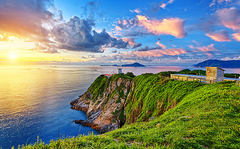 日出时美丽的灯塔地平线阳光蓝色场景戏剧性日落海岸海浪岩石海洋图片