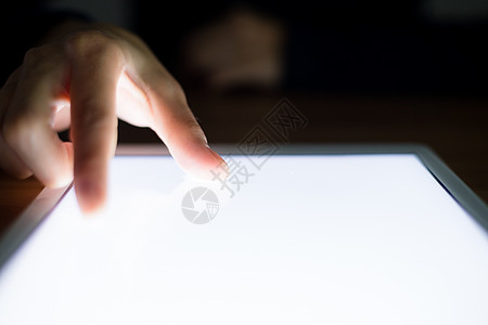 在平板电脑屏幕上使用手指的妇女图片