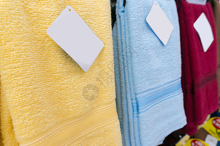 超市货架上的彩色毛巾大卖场黄色产品洗衣店架子织物标签蓝色亚麻纺织品图片