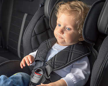坐在安全汽车座椅上的婴儿男孩图片