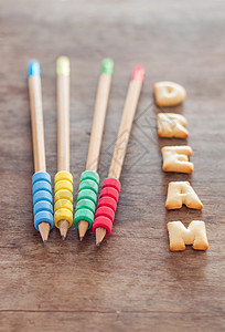 木制桌上的梦想字母饼干食物杯子英语小麦公司甜点营养小吃教育金子背景图片