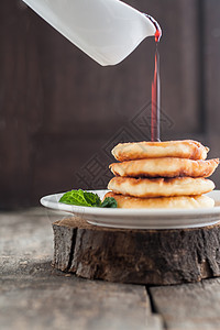 倒在面包干芝士煎饼果酱上 在黑木的背面蛋糕饼子煎饼木头糖浆小吃文化浆果薄荷早餐图片