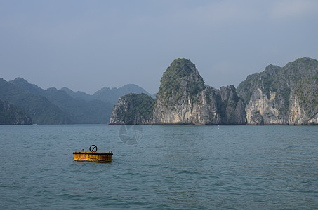 美丽的石灰岩山风景 在Ha Long带黄色浮标假期海洋天空旅游游客岩石石灰石旅行绿色海景图片