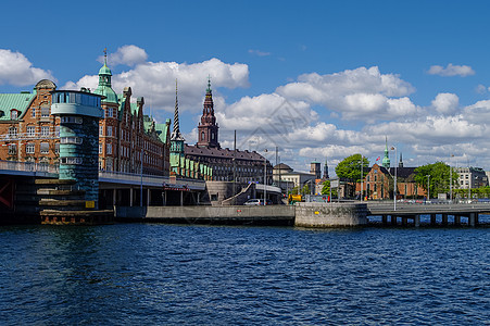 哥本哈根城市的运河景象和阳光明媚的堤岸上的房屋房子历史性景观建筑游客市中心蓝色街道天际教会图片