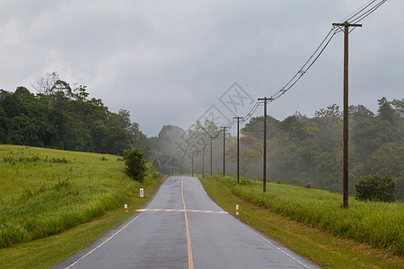 雨后潮湿的道路日落季节旅行运输街道城市戏剧性天气山脉反射图片