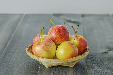 木木背景上的红苹果和黄苹果黄色水果营养饮食竹子篮子食物红色收成图片