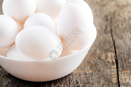 木制背景的白碗中的原鸡蛋白蛋家禽乡村动物早餐烹饪陶器农业木头蛋黄盘子图片