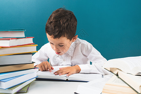 餐桌上看书的男孩子好奇心图书馆男生阅读童年学校学习蓝色黑板班级图片