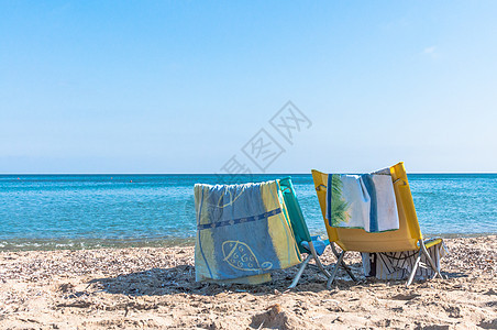 沙滩上的白椅子休息支撑旅游晴天蓝色白色天堂海岸海洋热带图片