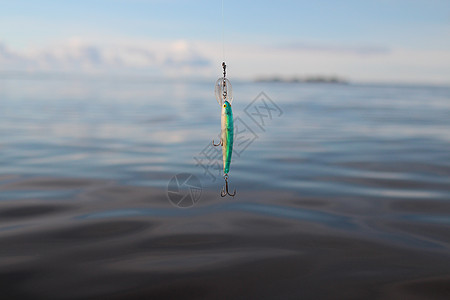 钓鱼线上的贩子纺纱蓝色海景垂钓者鱼钩钓饵图片