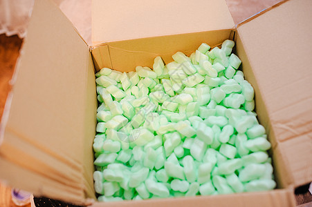 装满许多白色泡沫塑料颗粒的盒子水平花生空白绿色棕色船运包装填料邮件材料图片