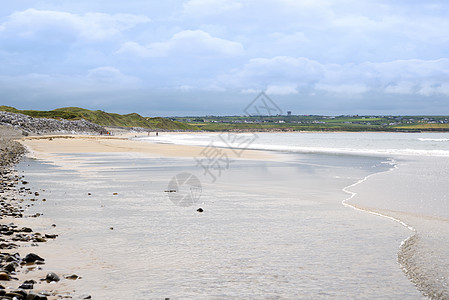 高尔夫球场旁的沙滩蓝色鹅卵石支撑假期石头海洋游客岩石场景波浪图片