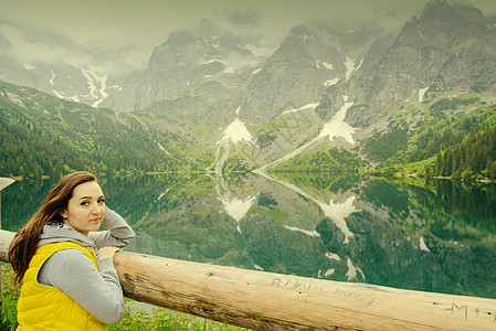 在湖边和山上放松的女士们 阳光明媚的风景石头女孩游客旅游旅行远足蓝色绿色冒险背包图片