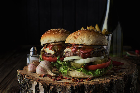 黑背景的两份牛肉汉堡木板刀具午餐洋葱烧烤沙拉芝士食物餐厅木头图片