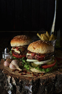 黑背景的两份牛肉汉堡蔬菜包子洋葱食物芝士刀具汉堡餐厅烧烤木板图片