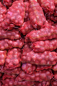 装有大洋葱 堆叠出售的沙克贸易市场贮存生产食物红色网袋商品场景囤积图片
