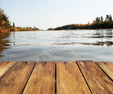 在湖边钓鱼农村蓝色公园反射木头海滩旅行天空太阳码头图片