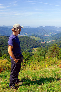 胡子人 徒步者 站在山上看远处 后视线 阳光明媚的日子图片