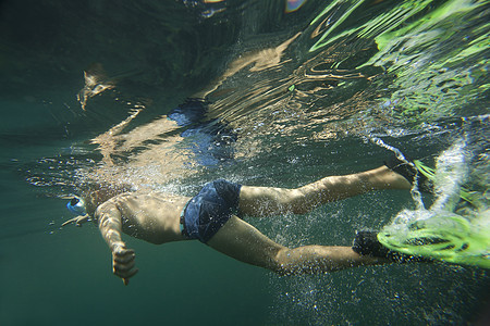 一只潜水器穿梭在飞毛腿的上下方游泳气泡运动潜水员潜水背景图片