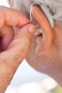 将助听器插入耳朵的高级妇女女性戒指损失老年援助卫生女士关节炎运河健康图片