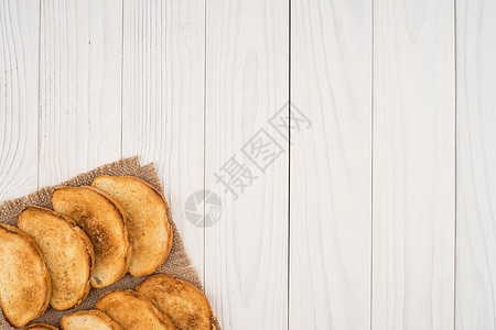 烤面包加薄饼和白木桌早餐脆皮白色面包桌子麻布油炸糕点小吃美食图片