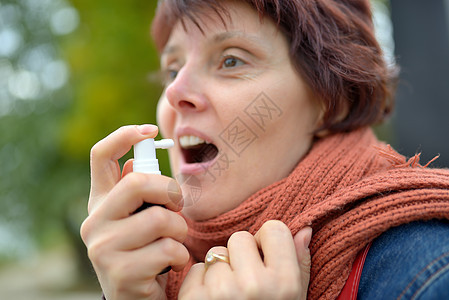 使用喉喷雾剂的年轻妇女流感温度弱点疼痛疾病女孩毛衣围巾症状心绞痛图片