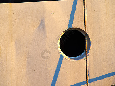 白色木制墙上的船轮窗口孔图片
